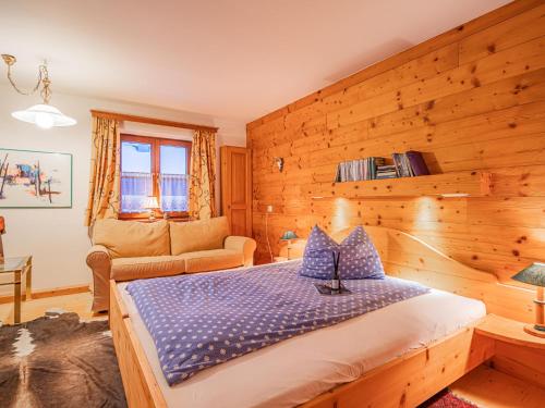 a bedroom with a bed and a wooden wall at Haus David in Kirchberg in Tirol