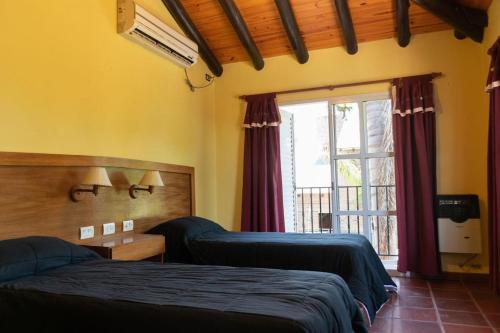 ein Schlafzimmer mit zwei Betten und einem Fenster in der Unterkunft Ñanderoga Bungalows in Colón