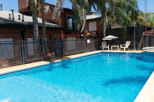 einen Pool mit blauem Wasser vor einem Haus in der Unterkunft Ñanderoga Bungalows in Colón