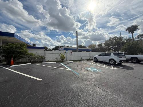 a white car parked in a parking lot at Rollie's Motel Daytona Beach by Hotel O in Holly Hill