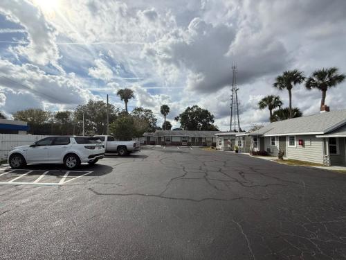 a parking lot with a car parked in front of a building at Rollie's Motel Daytona Beach by Hotel O in Holly Hill