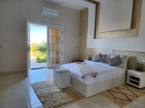 una camera da letto con un grande letto bianco e una finestra di Urti Villa a Nzala