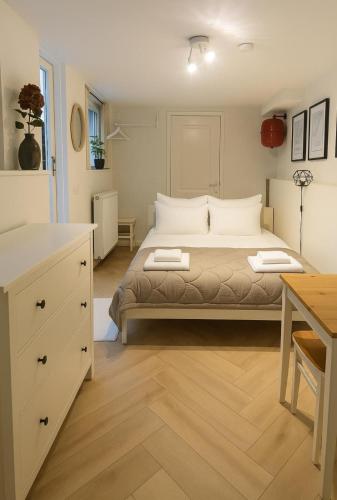 a bedroom with a large bed and a desk at Tiny House Bliss in Amsterdam