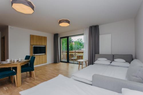 Un dormitorio con una cama y un comedor con una mesa. en Platinum Apartments, en Szklarska Poręba