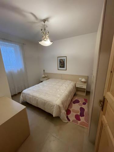 una camera da letto con un letto grande e un lampadario di Tabià Padola a Comèlico Superiore