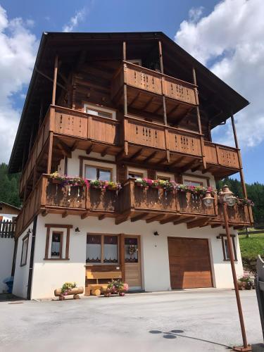 un edificio con balconi e fiori di Tabià Padola a Comèlico Superiore