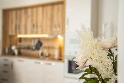 a vase with a white rose in a kitchen at Best Central Lux Studio in Bansko