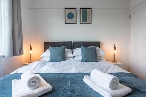 a bedroom with a large bed with towels on it at Briants, for Families & Contractors - Free Parking in Reading