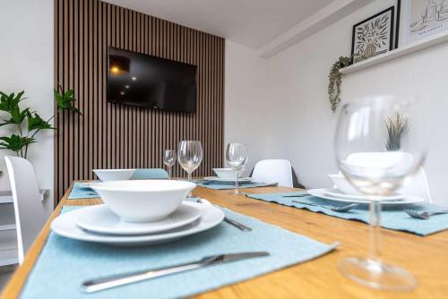 a dining room table with plates and wine glasses at Briants, for Families & Contractors - Free Parking in Reading