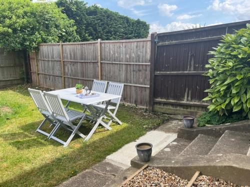 a table and chairs in a backyard with a fence at Briants, for Families & Contractors - Free Parking in Reading