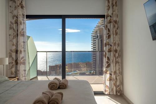 a bedroom with a large window with a view of the ocean at Sanset Waves with a sea view! in Benidorm