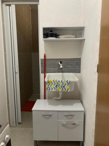 een kleine badkamer met een wastafel en een douche bij Kitnet Dream House 3 in Bayeux