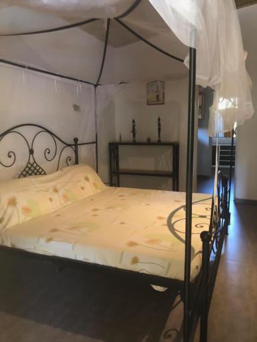 a bedroom with a bed with a canopy at VILLA Alia in Nianing