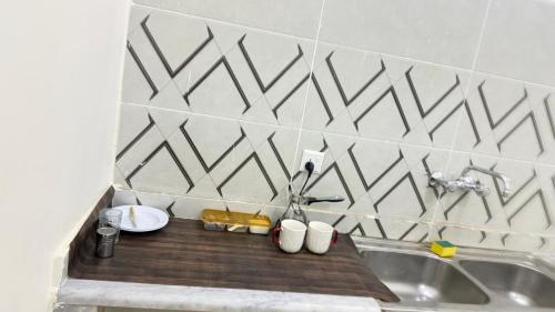 a kitchen with a sink and a counter with cups at هوستل خدمه مبيت in Disah