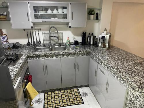 a kitchen with white cabinets and a sink at Ryad Lalla khadija in Marrakech