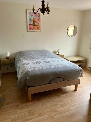 un lit dans une chambre avec deux tables et un miroir dans l'établissement Gîte Orchidée, à Ergersheim