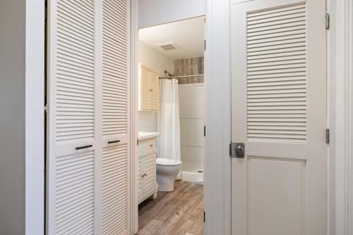 a bathroom with a toilet and a white door at Tee and Sea Getaway ay Turtle Bay in Kahuku
