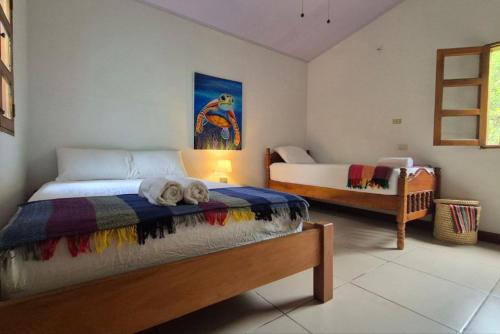 a bedroom with two beds in a room at Casa Andrew - Cozy Island Home in Santa Cruz