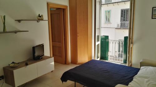 サレルノにあるIndipendenzaのベッドルーム(ベッド1台、テレビ、窓付)