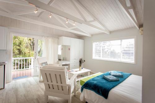 Un dormitorio con una cama y una mesa y sillas. en Slanting Acers - Unit B, en Wilderness