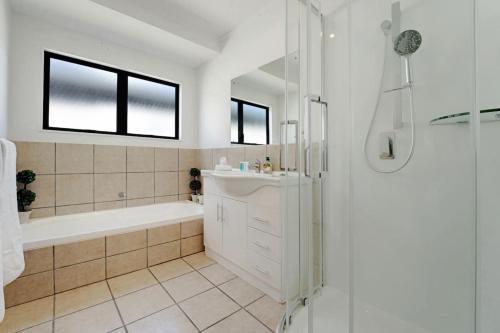 a bathroom with a tub and a sink and a shower at Seaside Premium Home with Spa Pool near Beach in Beachlands