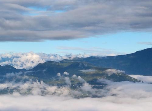 a view of a mountain covered in clouds from an airplane at Susanta Homestay , Icchegaon , Kalimpong in Kalimpong