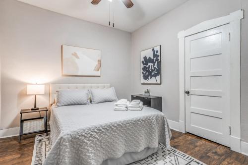 ein weißes Schlafzimmer mit einem Bett und einer weißen Tür in der Unterkunft Your Midtown Getaway - Central, Walkable and Calm in Memphis