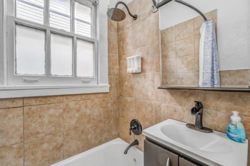 ein Badezimmer mit Waschbecken und Spiegel in der Unterkunft Your Midtown Getaway - Central, Walkable and Calm in Memphis