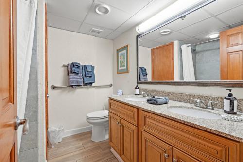 une salle de bains avec lavabo, toilettes et miroir dans l'établissement Beach Cove Resort Oceanfront Unit 314 with Balcony, à Myrtle Beach