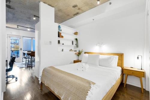 una camera da letto con un letto grande e una scrivania di Pristine Parc Avenue Pad With Parking a Montréal