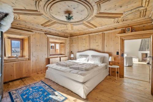 萨梅丹3 camere Antico Fienile nel centro di Samedan的卧室配有白色的床和格子天花板