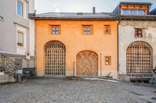 萨梅丹3 camere Antico Fienile nel centro di Samedan的一座橙色的建筑,设有两个大型木门