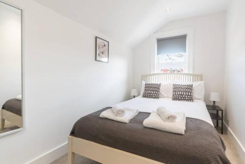 a bedroom with a bed with two towels on it at Westfield Town-House Free Parking, Secure Garden in Caversham