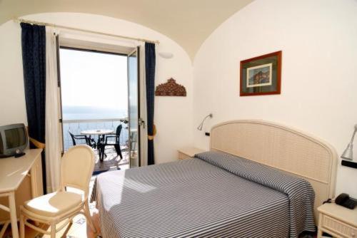 a bedroom with a bed and a view of the ocean at Hotel Bellevue Suite in Amalfi