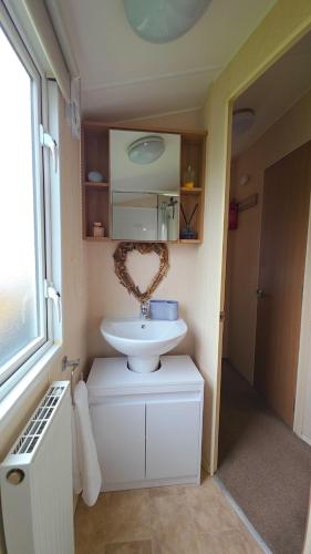 a bathroom with a white sink and a mirror at 17 Ruby Atlas Monreith in Monreith