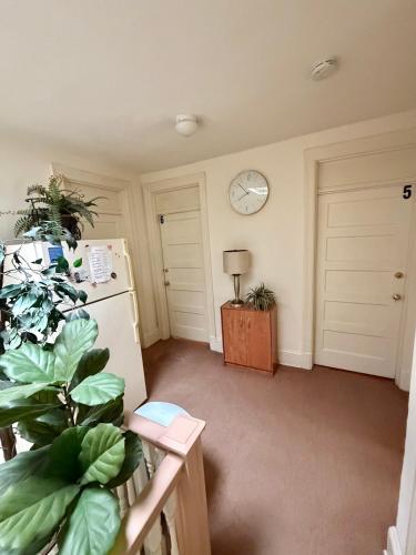 a room with a refrigerator and a clock on the wall at Pleasant Rooming House in Washington, D.C.