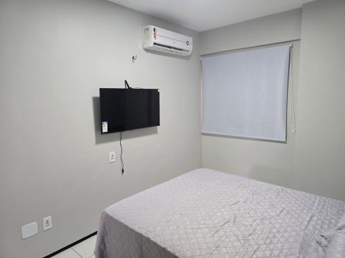 Una televisión o centro de entretenimiento en Flat Biarritz - Praia Litorânea