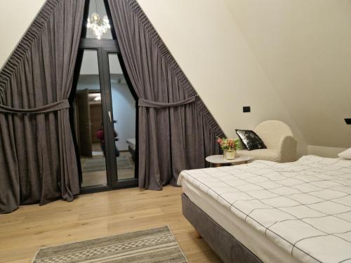 een slaapkamer met een bed en een groot raam bij Vila Timeea in Statjunea Borsa