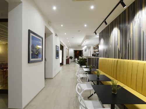 un ristorante con tavoli neri e sedie bianche di Best Western Hotel Martello a Lampedusa