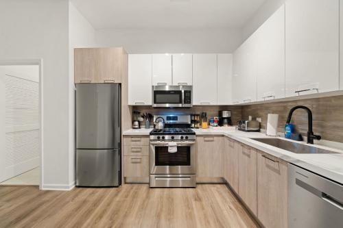 eine Küche mit Küchengeräten aus Edelstahl und Holzschränken in der Unterkunft Spacious 3BR Urban Getaway w Gym in Chicago