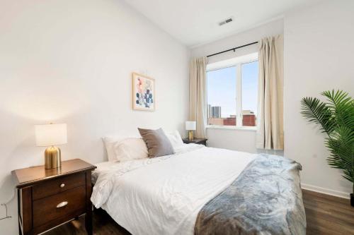 ein weißes Schlafzimmer mit einem großen Bett und einem Fenster in der Unterkunft Spacious 3BR Urban Getaway w Gym in Chicago