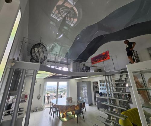 a dining room with a table and a ceiling with skylights at Villa Paradiso by Monarca Prestige in Furiani