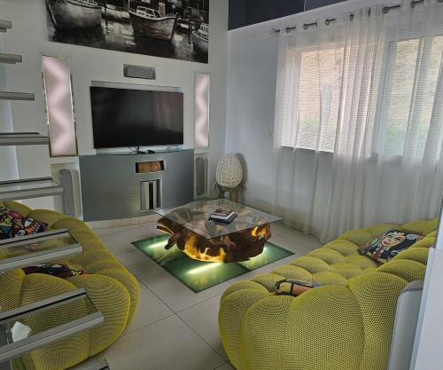 a living room with a fireplace and a tv at Villa Paradiso by Monarca Prestige in Furiani