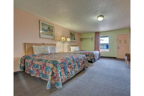 a hotel room with two beds and a window at American Inn by Hotel O Vernon US 287 in Vernon