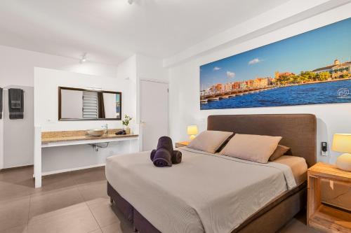 Un dormitorio con una cama y un escritorio. en Goudhaen Luxury Private apartments Jan Thiel Beach, en Jan Thiel