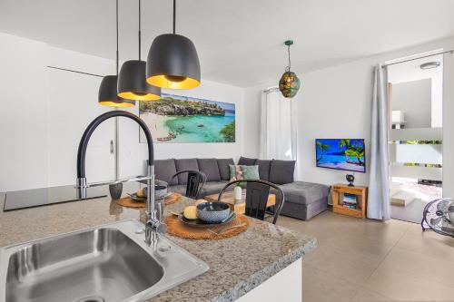 Una cocina con fregadero y una sala de estar. en Goudhaen Luxury Private apartments Jan Thiel Beach, en Jan Thiel