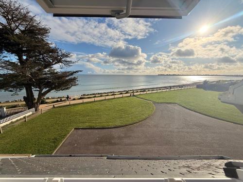 een uitzicht op het strand vanaf de veranda van een huis bij L îlot d Arthur in Île-Tudy