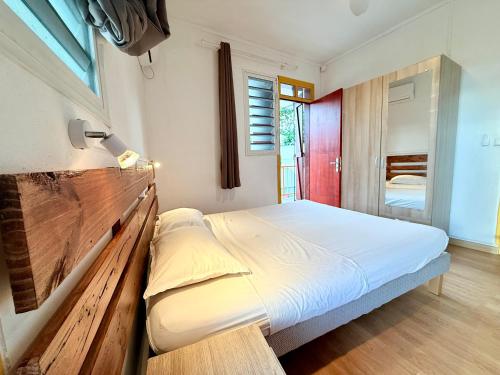 a bedroom with a bed with a wooden headboard at JSG Locations in Sainte-Anne