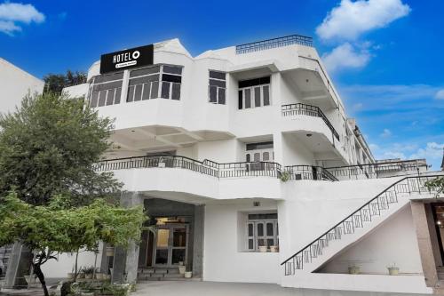 Hotel O Buddha Statue Gaya Formerly Uruvela International في بود جايا: مبنى ابيض عليه لافته