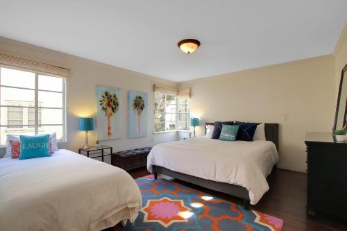 a bedroom with two beds and a rug at West Beach Villa 1 in Santa Barbara